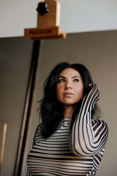 Angelica Ray in a reflective pose, looking upward and embodying empowered transformation and spiritual connection