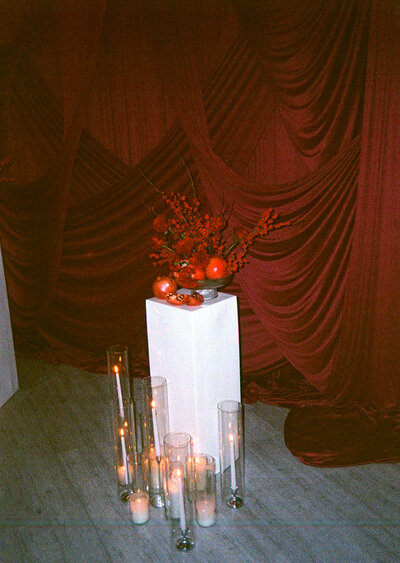 Film Wedding Photography with candles, red florals, and red draping