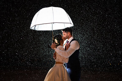 couple kissing under umbrella in the snow