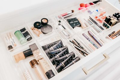 A bathroom drawer shows organized beauty products