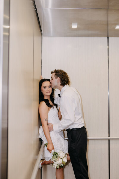a couple enjoying a romantic kiss in a elevator on the night of their weding 