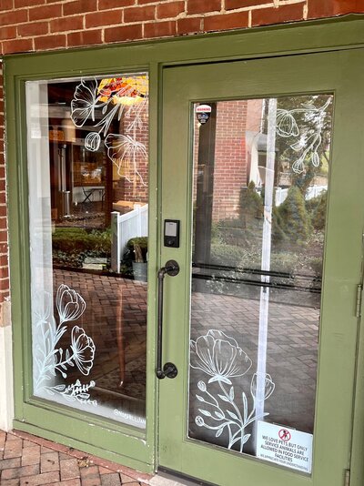 Hand drawn spring flowers on storefront windows of Cheshire, Connecticut business