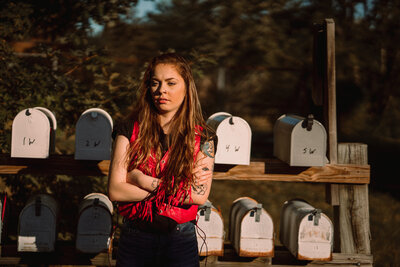 Girl stands in front of a row of mailboxes at an abandoned motel in Tennessee.