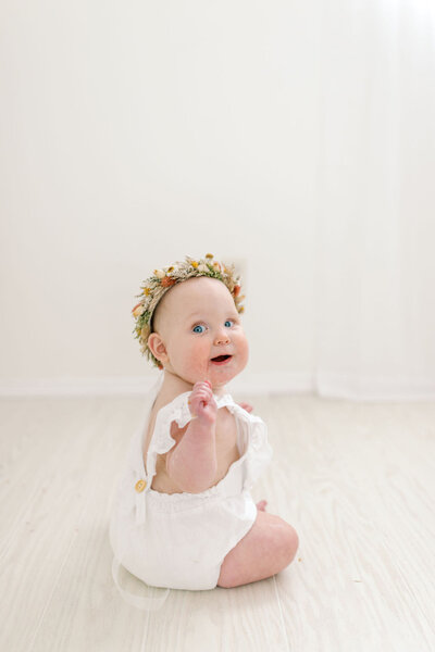 one year old girl smiling  in photo studio near me