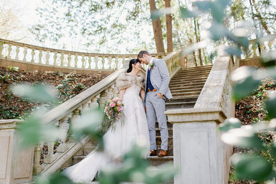 Bride and groom stand on stairs at Cator Woolford Gardens