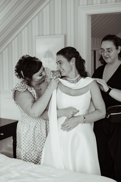 Rachel and other women helping bride with her wedding dress