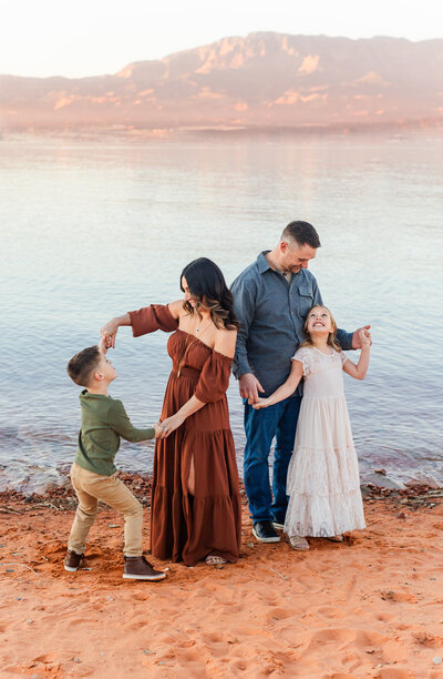 mom and dad and two kids playing on the beach at sand hollow photo taken by Sadie Peterson Photography