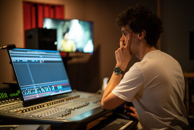 Music Producer Jakob Reinhardt sitting behind a recording console in a music studio.