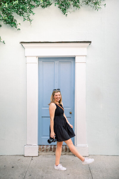 girl kicking foot out in front of blue door in charleston