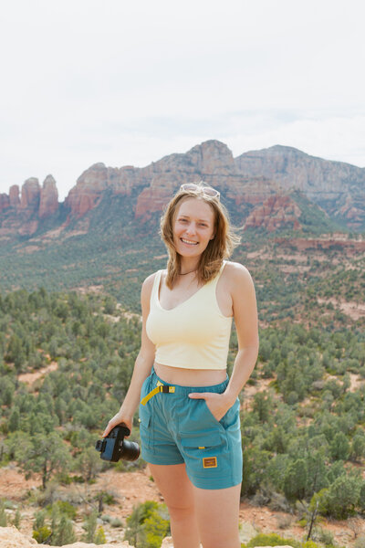 Brisa smiling while hiking in Sedona with camera in hand.