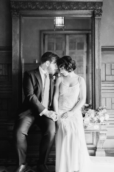 Newlyweds sit forehead to forehead.