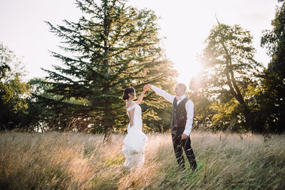 A newly married couple dancing in a woodland area during golden hour taken by Cornwall Wedding Photographer and Devon Wedding Photographer Liberty Pearl