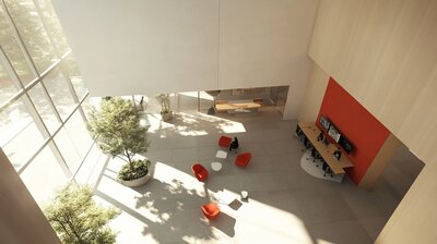 pohled shora do dvorany velké světlé budovy, v přízemí jsou oranžová křesílka, bílo konferenční stolky a velké okno od podlahy až nahoru