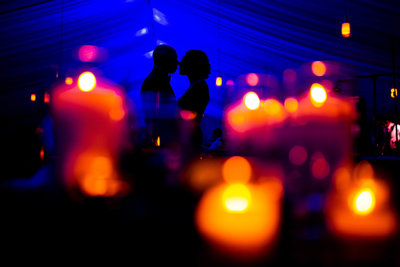 A silhouetted couple in candlelight.