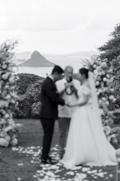 A couple holding hands as they say their vows at their wedding 