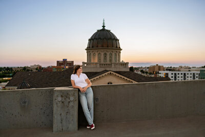 A high school senior stands on top of a parking garage rooftop for her senior photos in downtown Oklahoma City.