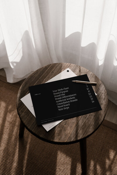 Flat lay of brand strategy documents and creative direction guide on a wooden table, part of the Moonstone Brand Star Chart process.