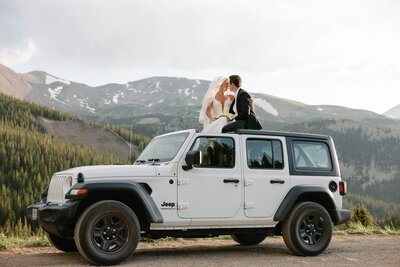 bride and groom sit on top of Jeep during Colorado elopement