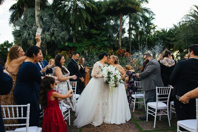 Silhouette of two men kissing with the blue sky and ocean behind them at their Micro Wedding