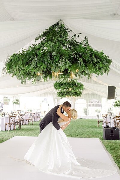 groom kissing bride in reception tent