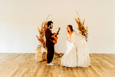 married couple dancing as husband plays guitar and wife dances