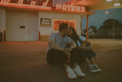 A retro-style film photograph of a couple under glowing neon lights, capturing vintage romance.