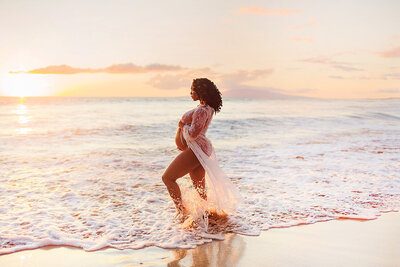 Maui maternity photography client posing at sunset on the shoreline in Wailea