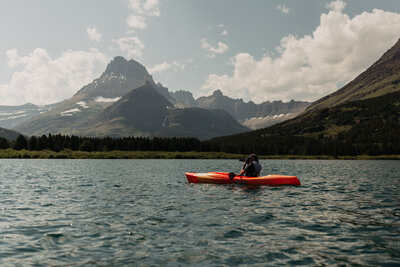 Montana elopement videographer floating in kayak on Swiftcurrent Lake in Glacier National Park