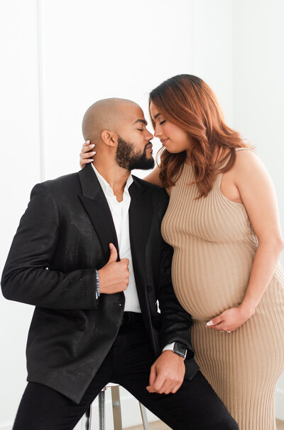 mom making a heart over her belly maternity session white dress by miami maternity photographer msp photography David and Meivys Suarez