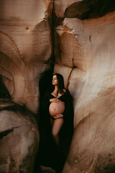 Maternity photoshoot in picturesque rock formations at the beach