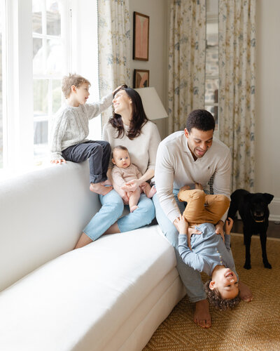 Parents play with their 3 young children during in-home family portrait session