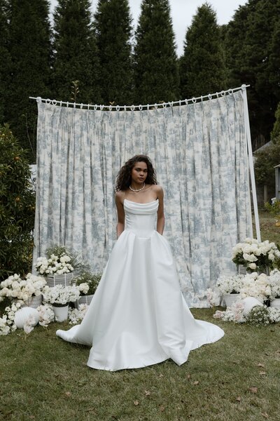 black and white image bride wearing strapless satin wedding dress with long train