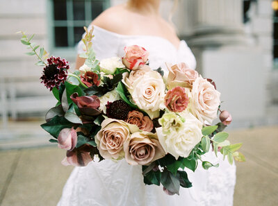 Bride posing in front of fireplace with florals