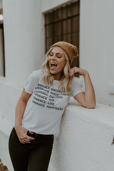 Kylee Grace laughing and leaning against a ledge