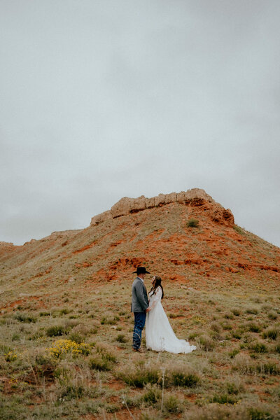bride and groom portrait against the red rocks at their ranch wedding