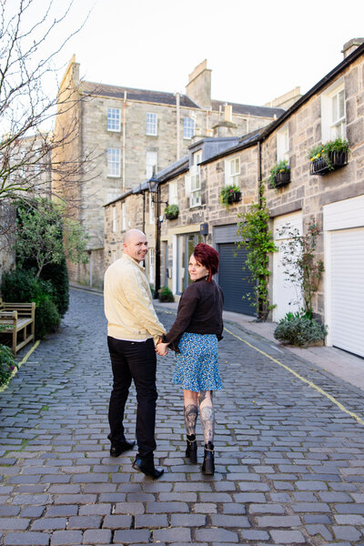 bride and groom walk down Circus Lane during their engagement photo