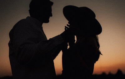 Kansas engagement session during sunset creating a beautiful silhouette image of the couple holding hands and looking at each other