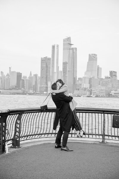 Couple rejoices after a Proposal in Jersey City, with the NYC skyline in view.  Photo taken by NYC Proposal Photographer Corey Lamar Photography