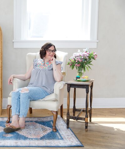 Copywriter for photographers Sara Gillis sitting on a chair