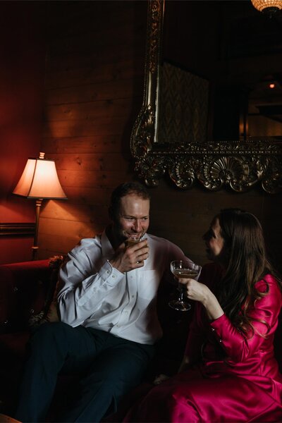Man and woman sip on drinks at at their engagement session in Bozeman.