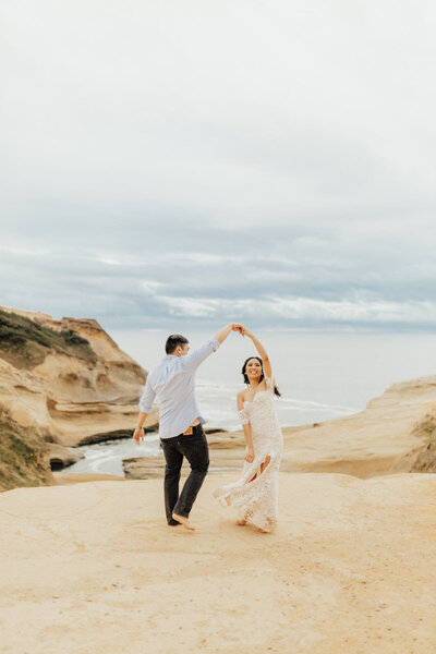 bride and groom dancing by the ocean