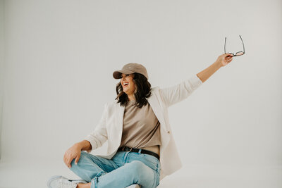 Female entrepreneur smiling while working on a laptop – marketing systems for coaches and creatives