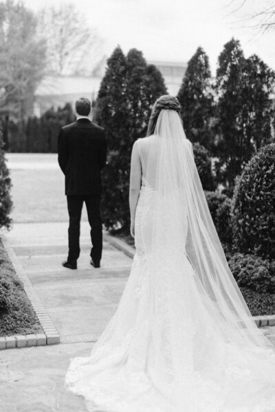 black and white image of bride looking off to groom