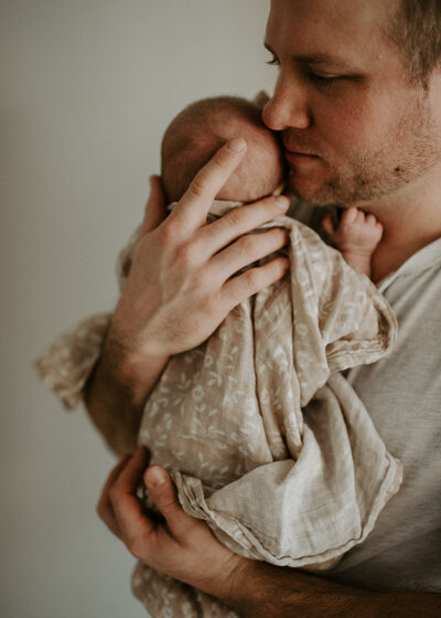 Newborn baby girl surrounded by flowers.