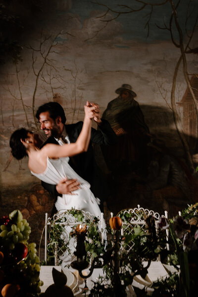 A newlywed couple smiling and dancing together 