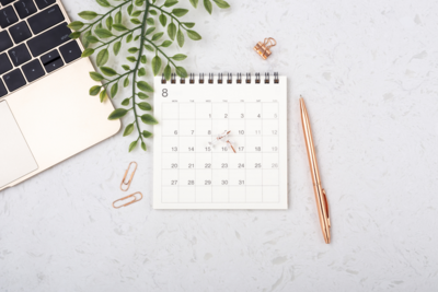 Calendar next to a computer and other feminine office supplies