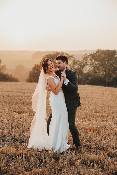 bride and groom dance in field of wheat