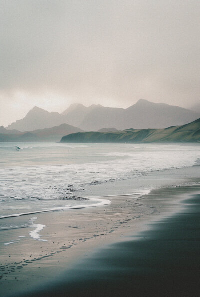 dark sand with ocean waves coming in and out