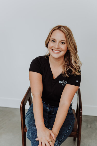 megan poses in front of a chair