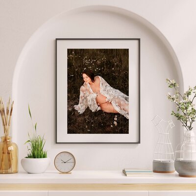 framed maternity photo of pregnant mo laying in field of flowers